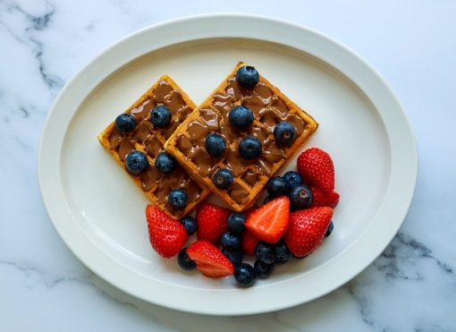 Waffles with fresh blueberries and strawberries as toppings.